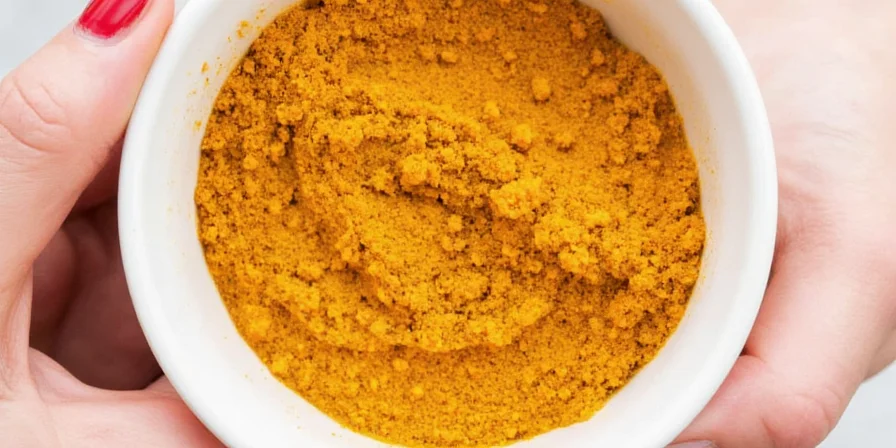 Chef wearing gloves while mixing turmeric into chili