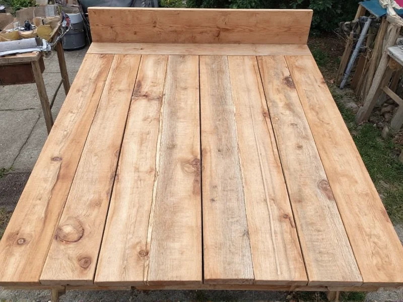 Reclaimed wood pieces laid out for bed base construction