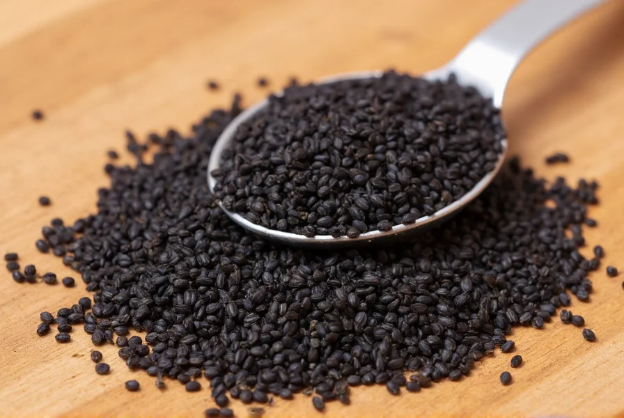 Close-up photograph of black nigella sativa seeds on wooden surface with measuring spoon