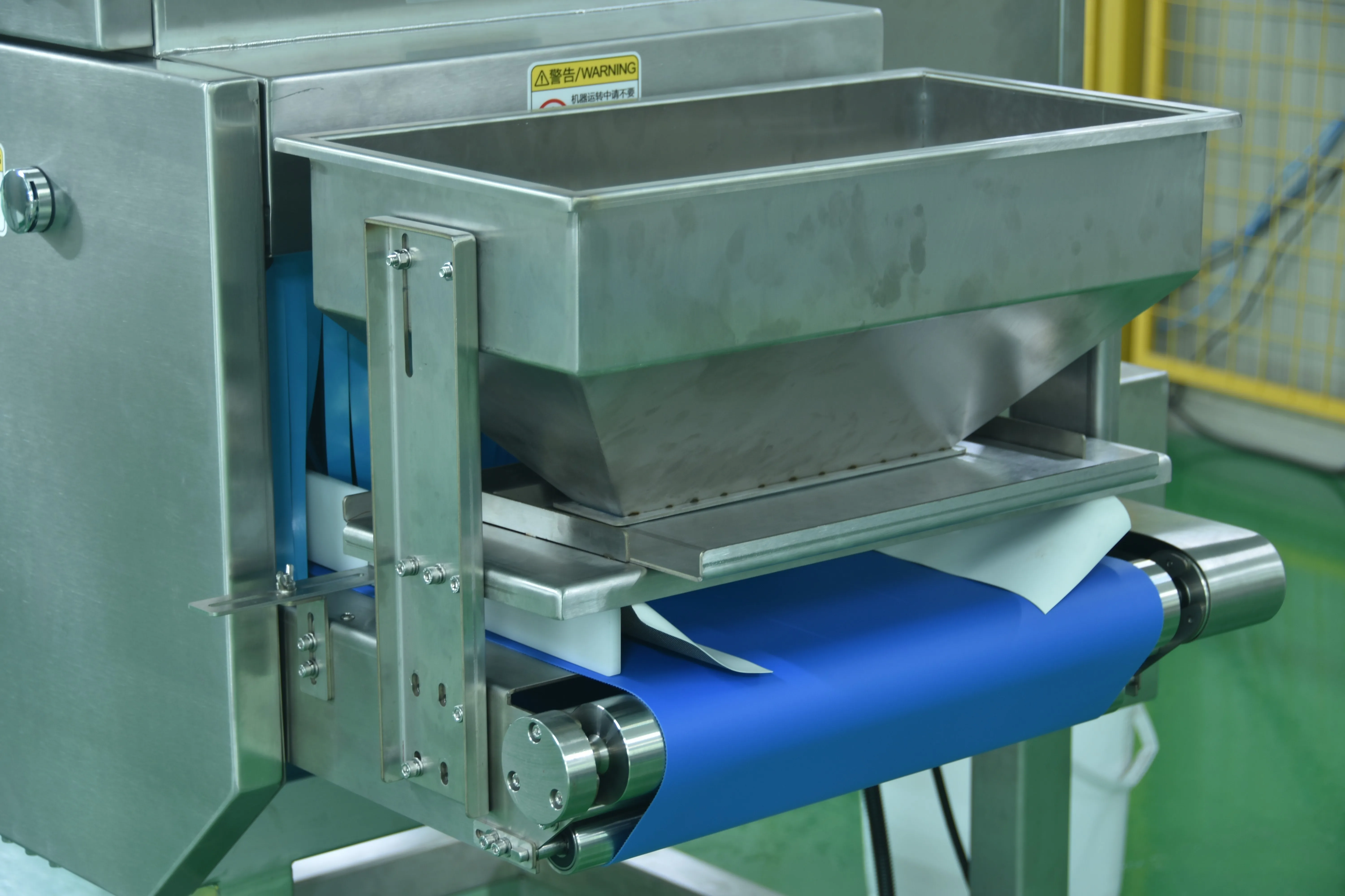 Stainless steel hopper feeding products onto the conveyor