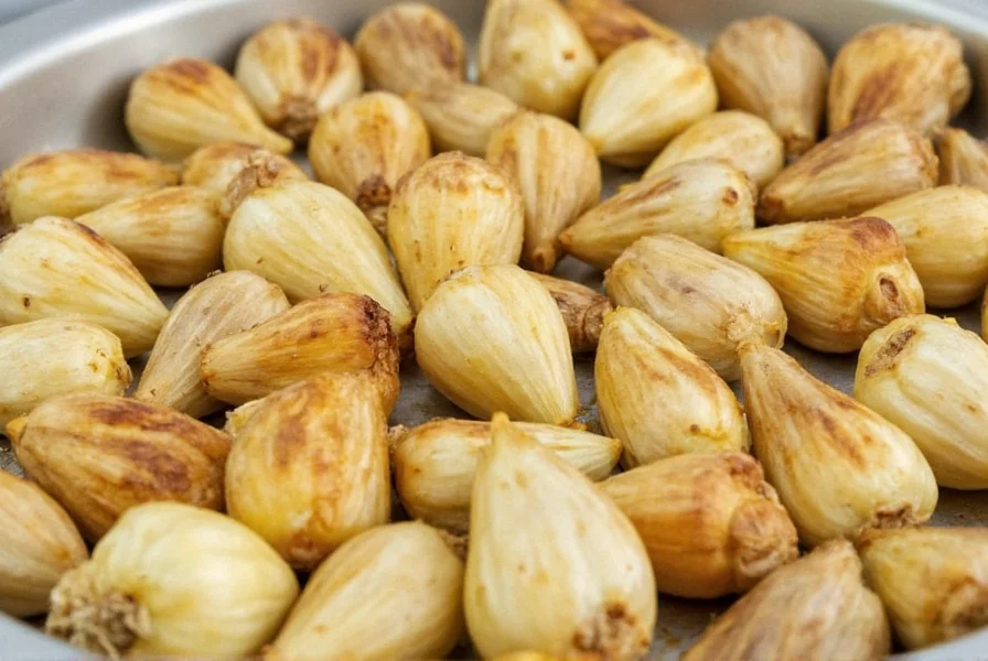 Perfectly roasted golden garlic cloves on wooden board