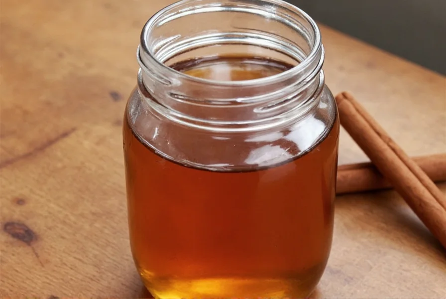 Close-up of cinnamon sticks simmering in clear syrup with sugar crystals visible