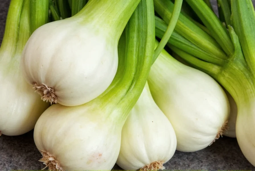 Fresh fennel bulbs with green stalks and fronds on a wooden cutting board