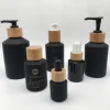 Factory hot sell cosmetic packaging frosted black glass bottle and jar with bamboo lid
