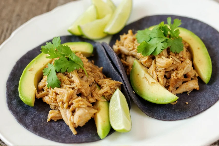 Jalapeño chicken tacos with fresh cilantro, avocado slices, and lime wedges on blue corn tortillas