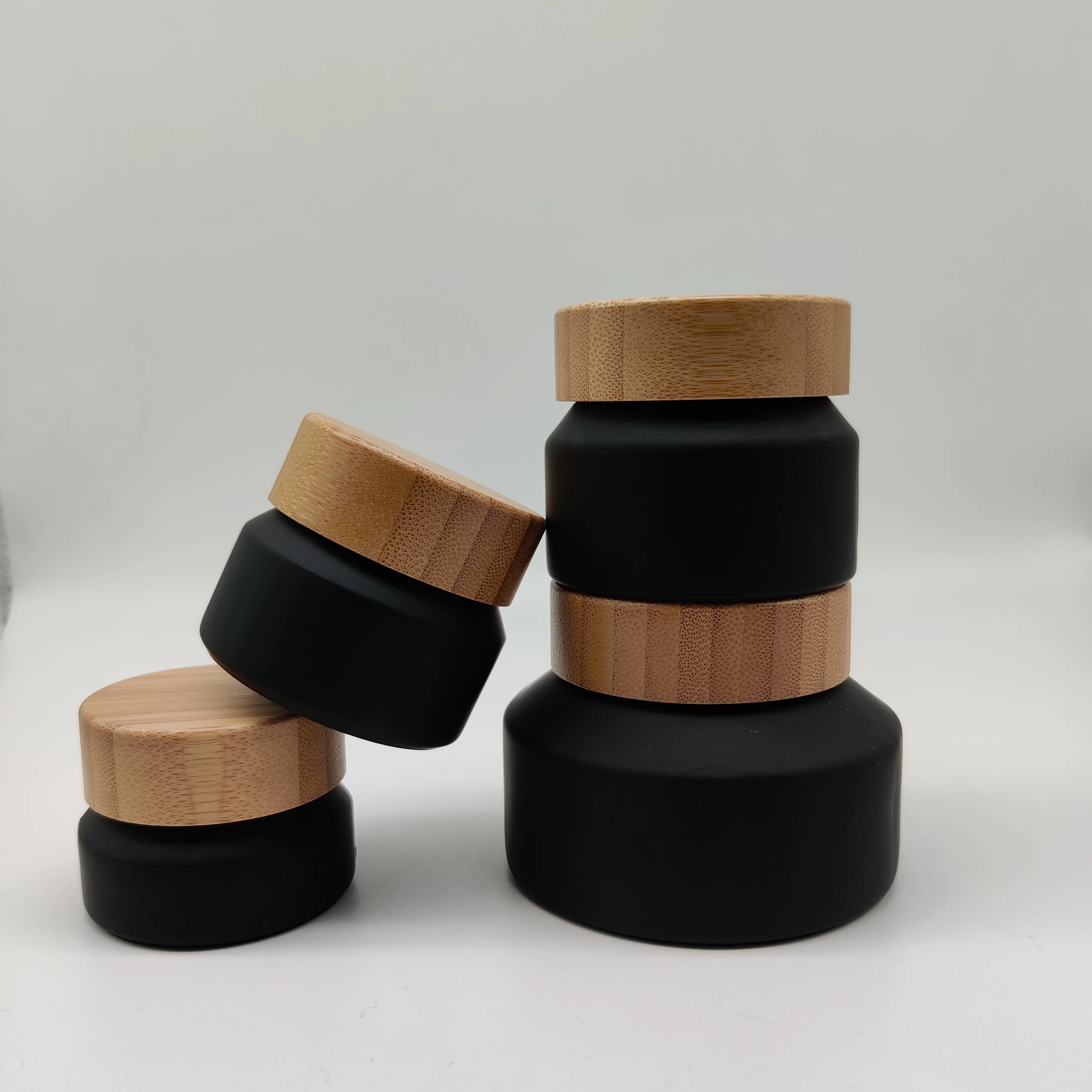 

Cosmetic packaging 50ml frosted black glass jar with dark wooden lid