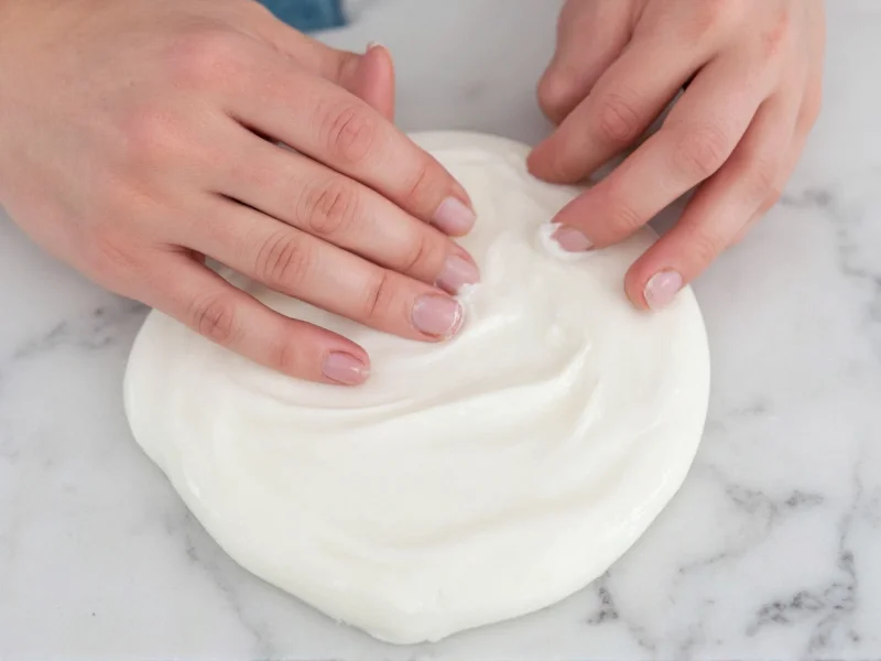 Hands kneading glossy slime on marble surface