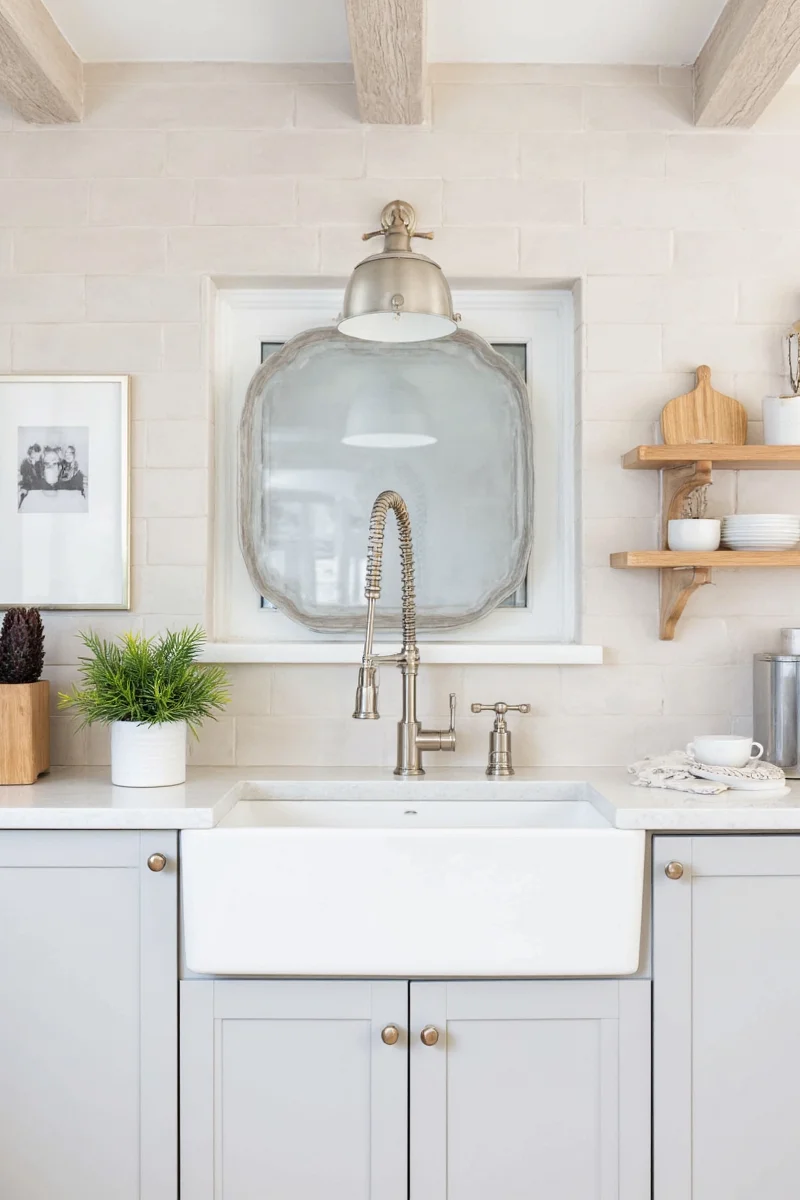 A busy mom using a modern kitchen faucet while her kids play nearby.