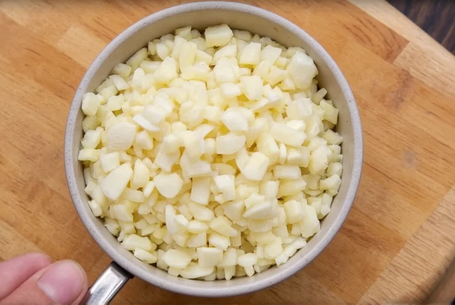 Chef measuring minced garlic in a teaspoon