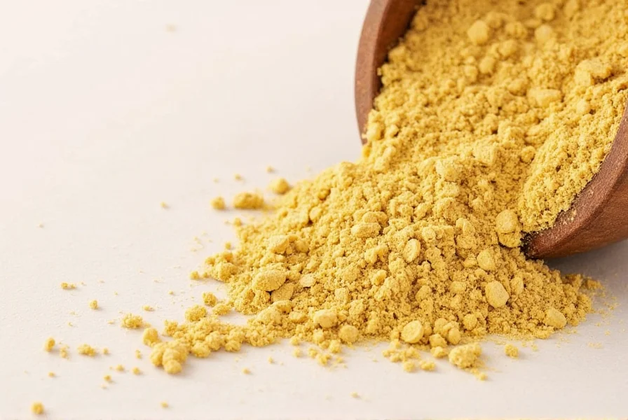 Close-up of golden ginger powder in a glass jar with measuring spoons showing proper substitution ratios for cooking