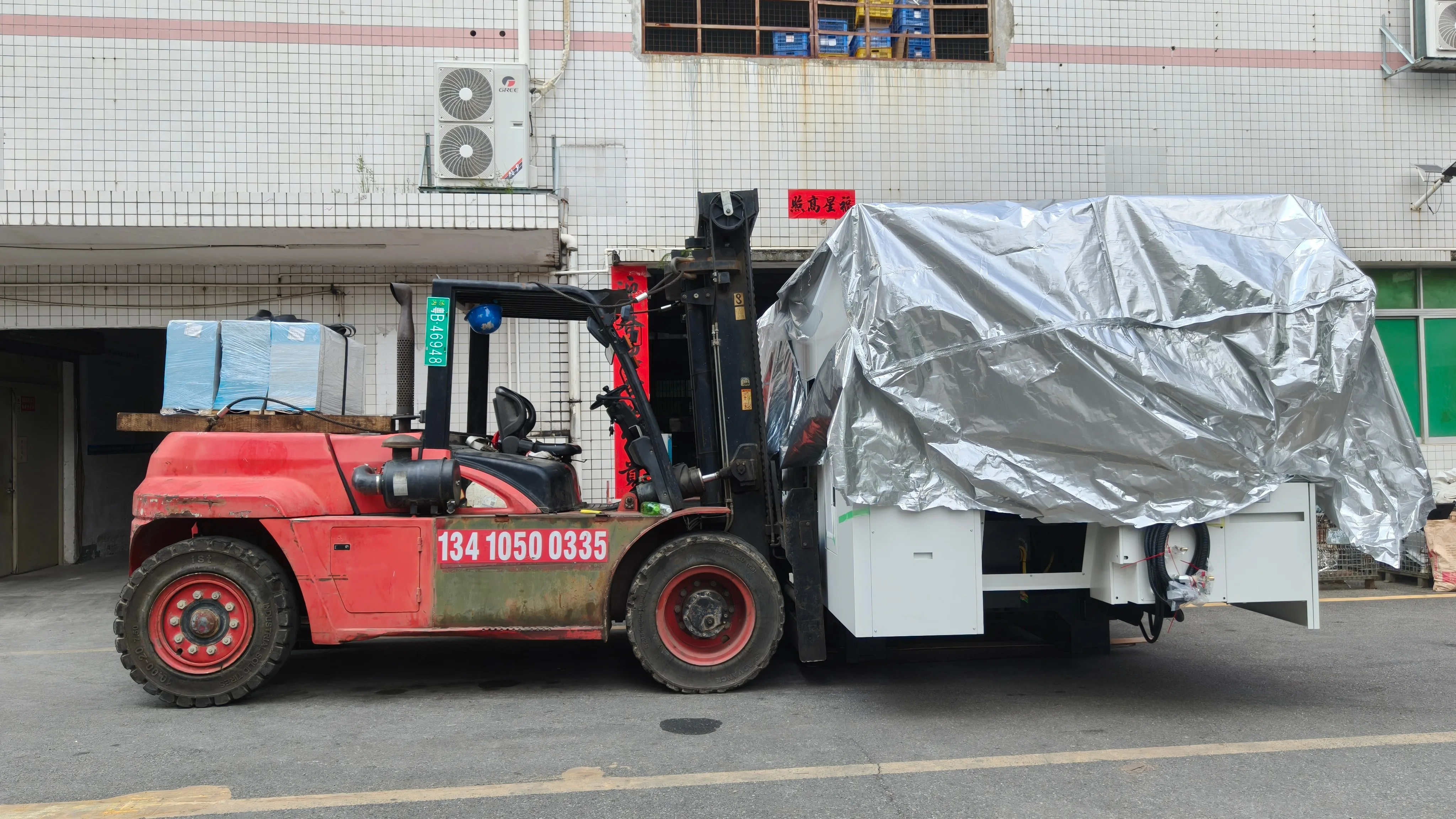 Forklift transferring the 5-axis machining center into the machine shop