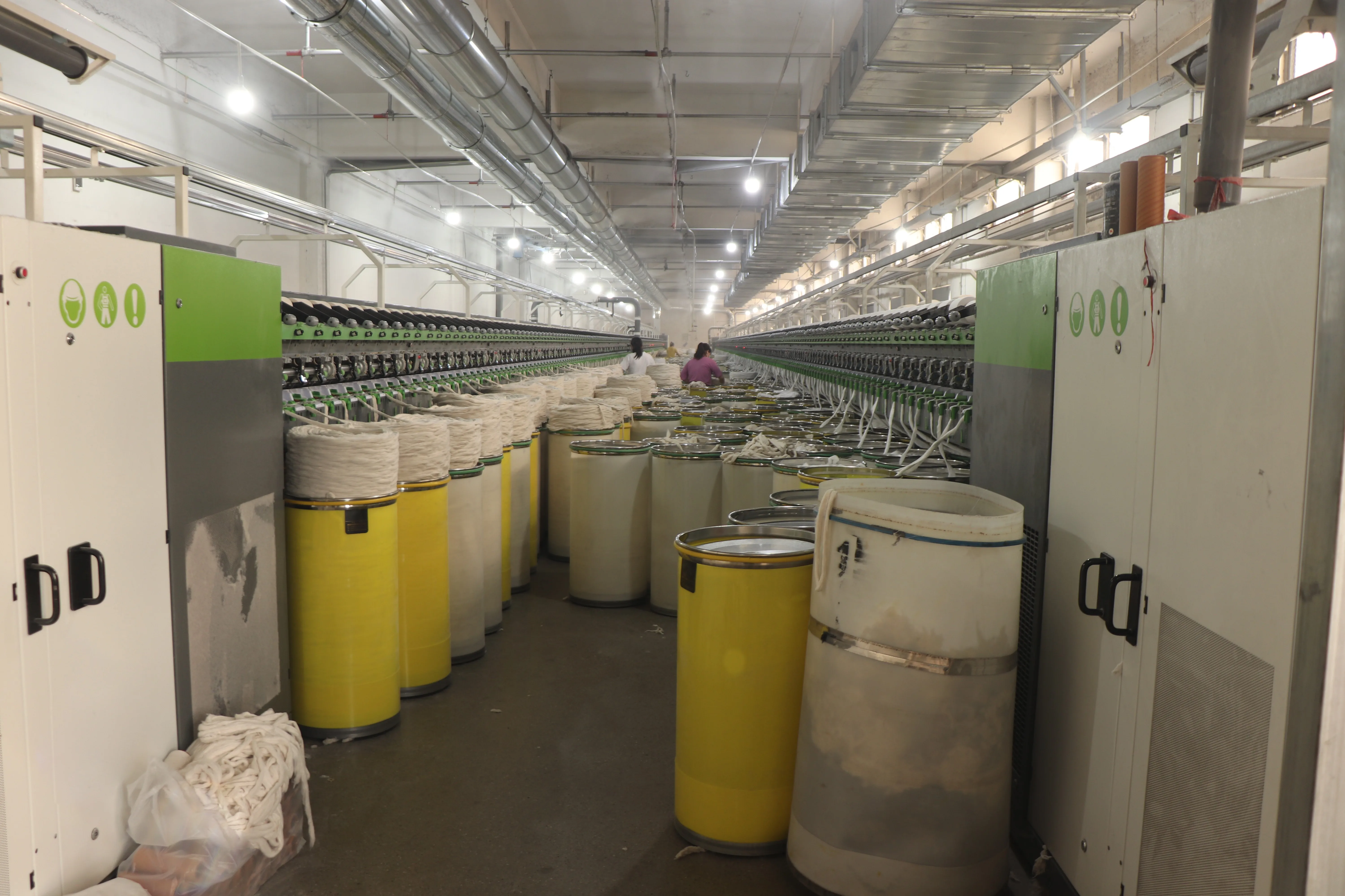Rows of sliver cans feeding a long spinning frame on a cotton yarn spinning floor