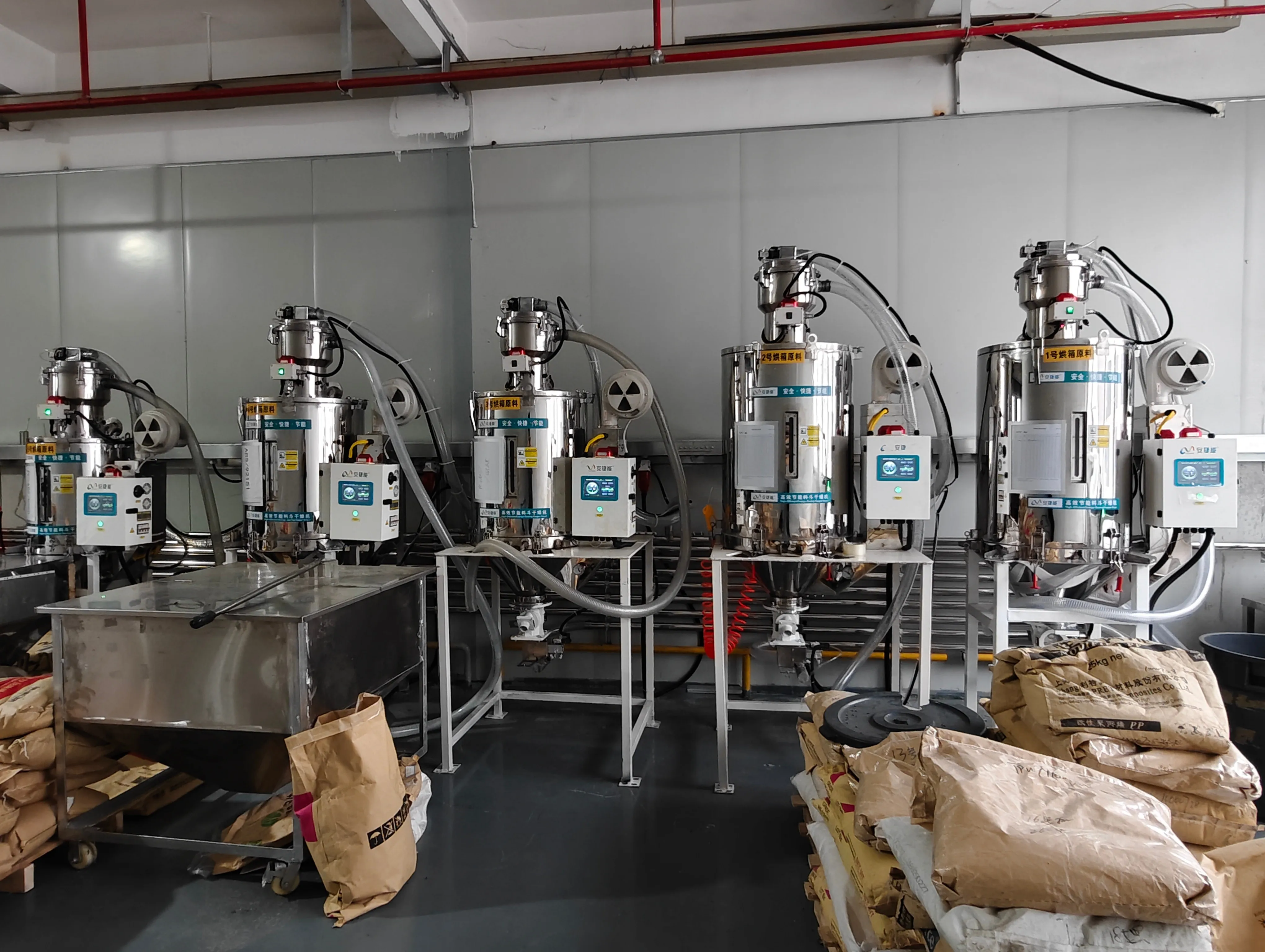 A standardized row of dryers with clear "Oven 1" and "Oven 2" material labels; modified material on site A standardized row of dryers with clear "Oven 1" and "Oven 2" material labels; modified material on site