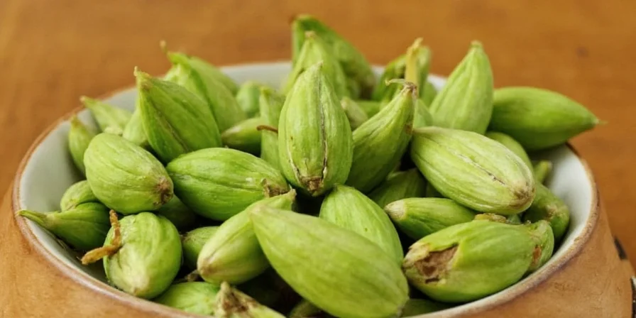 Green cardamom pods on wooden table