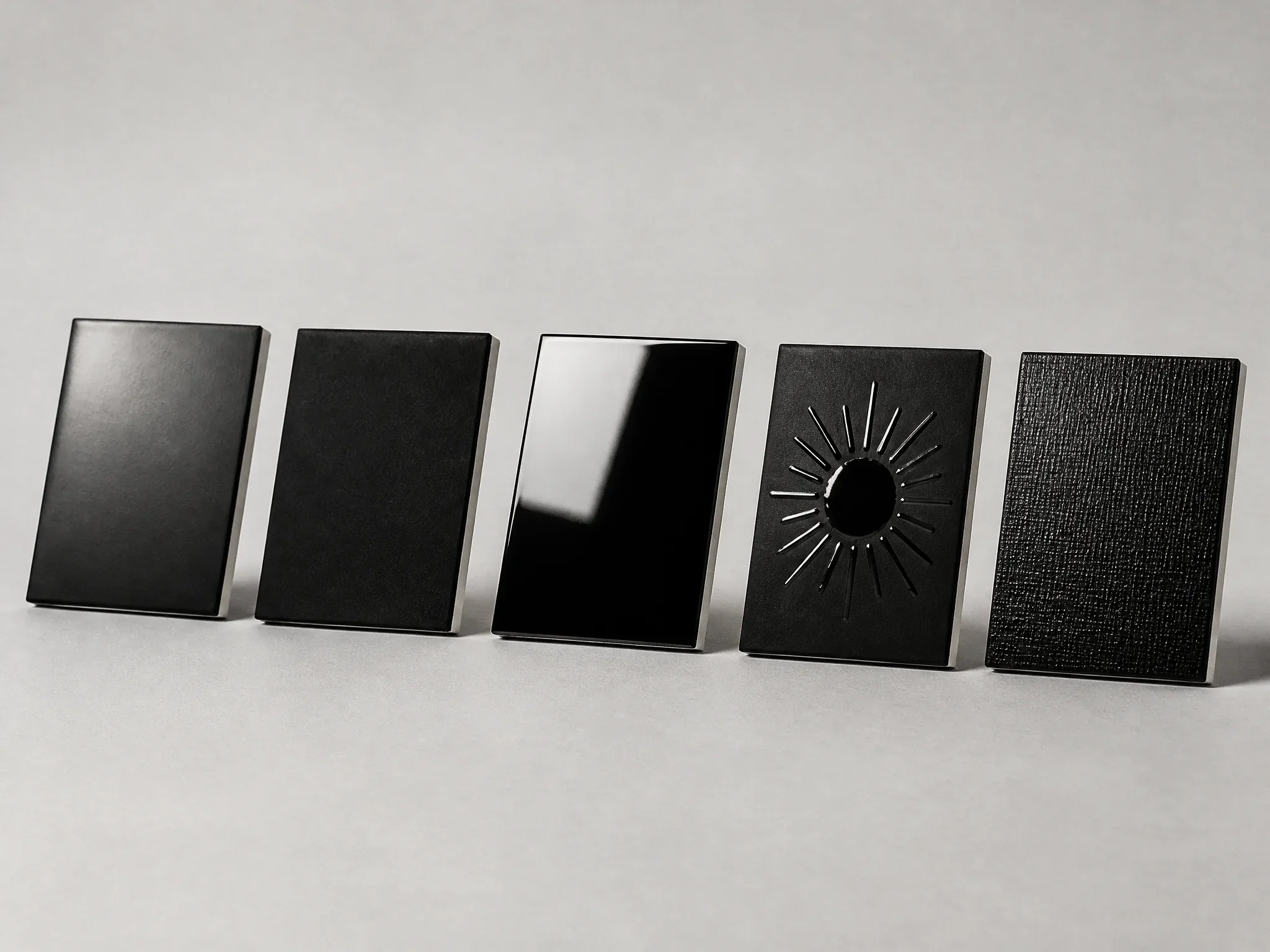 Five black box lid finishes side by side: matte, soft touch, gloss, spot UV and textured film