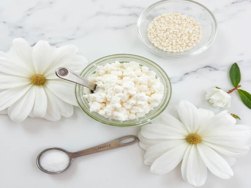 Homemade toothpaste ingredients in glass jar with measuring spoons