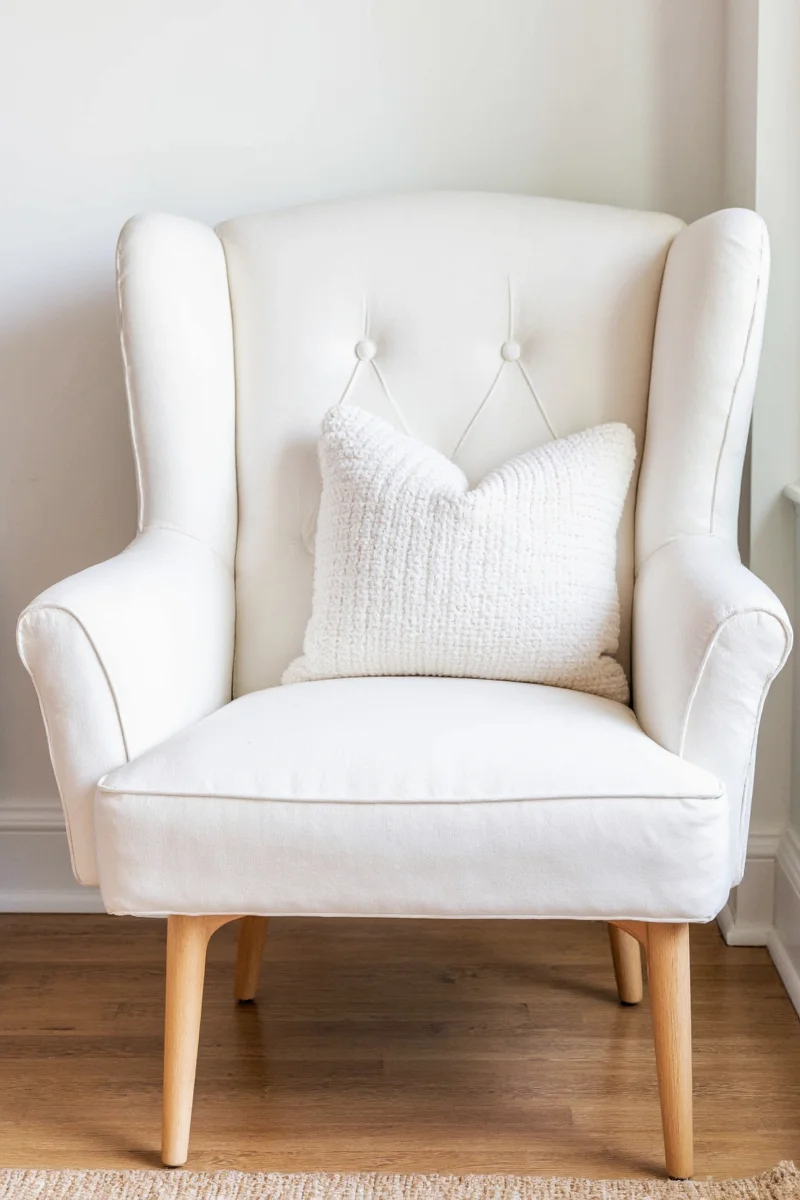 White chair couch styled with colorful cushions and throws