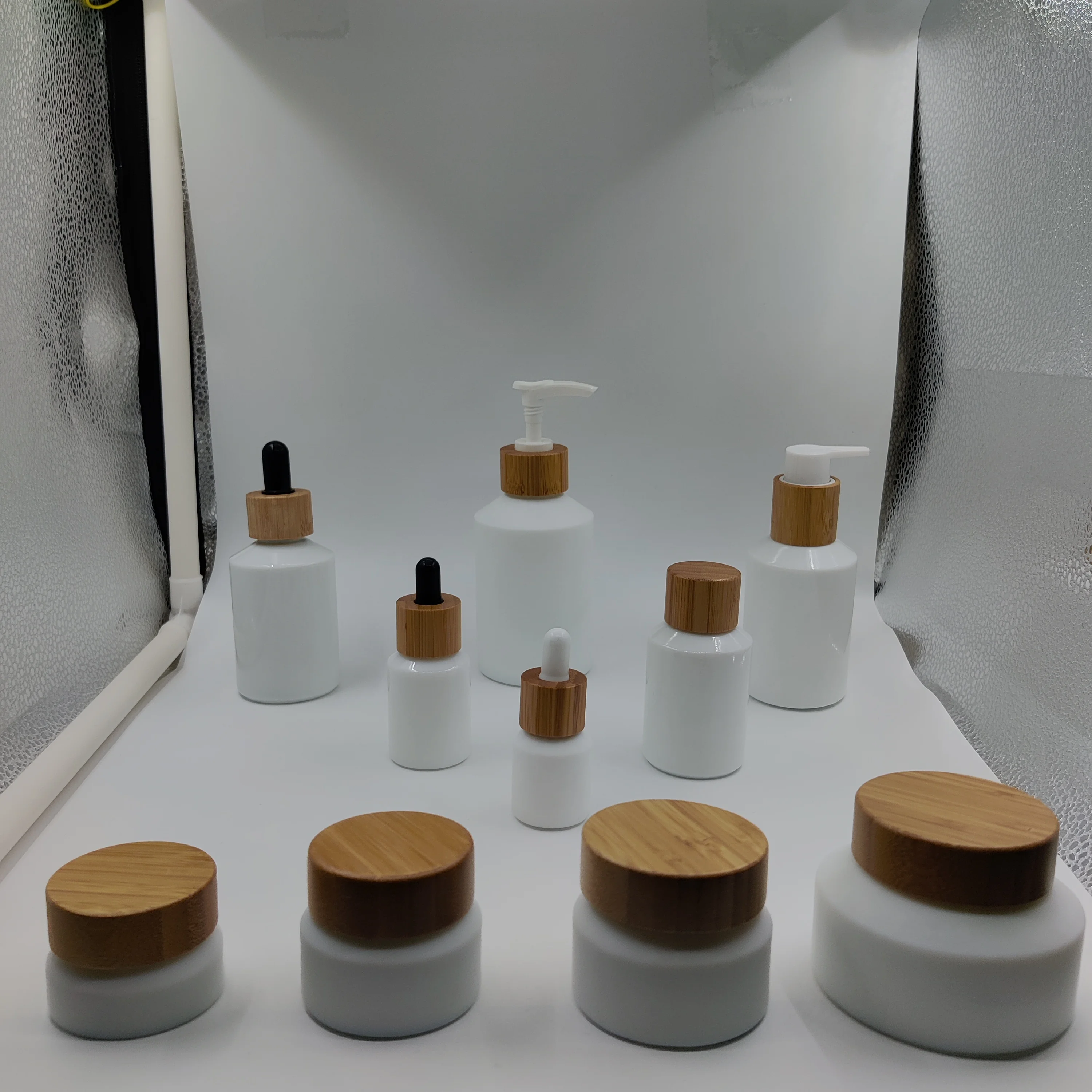 

cosmetic packaging opal white slant shoulder glass bottle and jar with bamboo/wooden lid and white plastic dropper