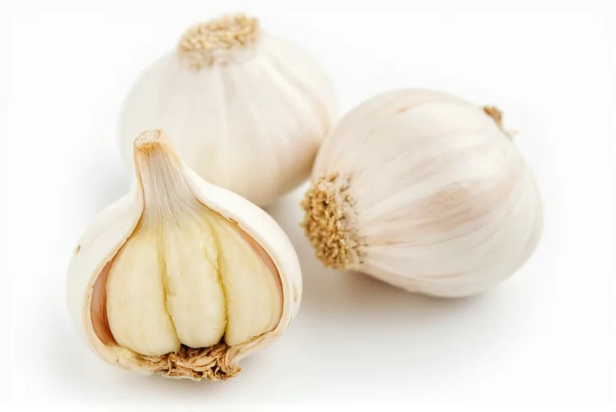 Chef's hands mincing fresh garlic on wooden cutting board with measuring spoons nearby