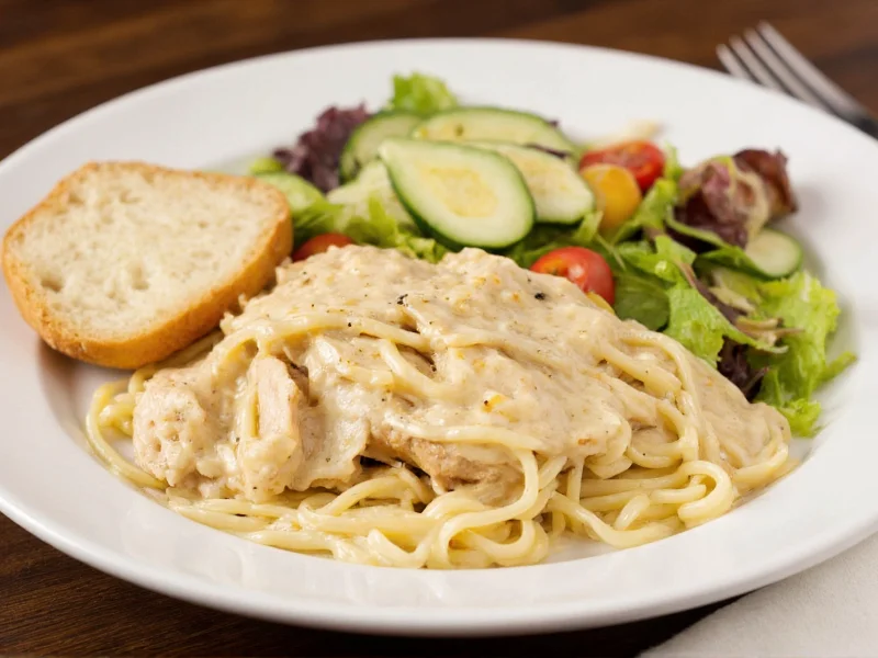 Chicken alfredo served with side salad and garlic bread