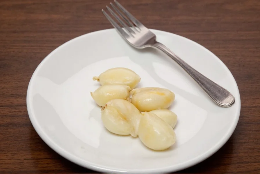 Two medium garlic cloves next to teaspoon measurements