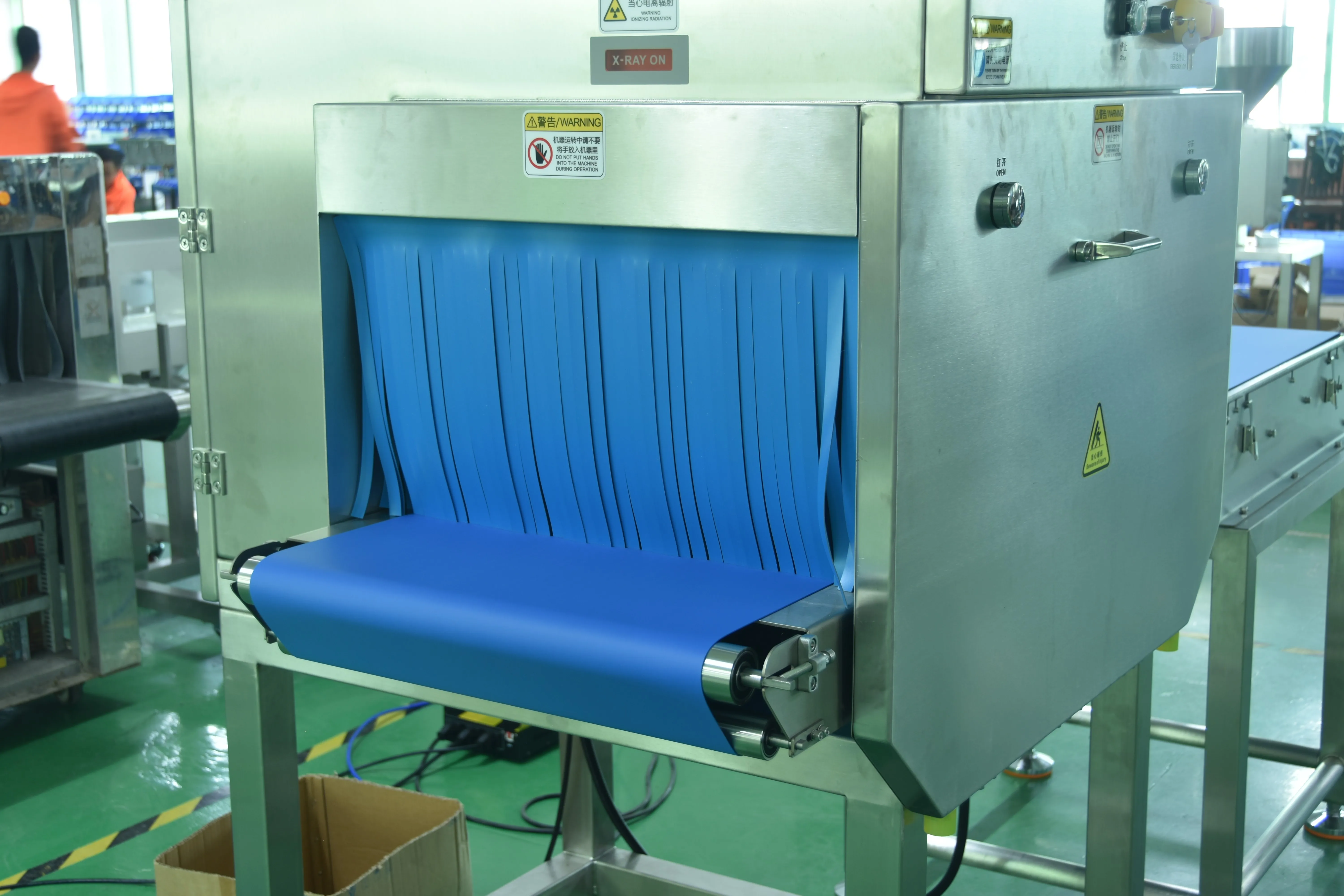 Heavy tunnel entry with lead curtains and conveyor