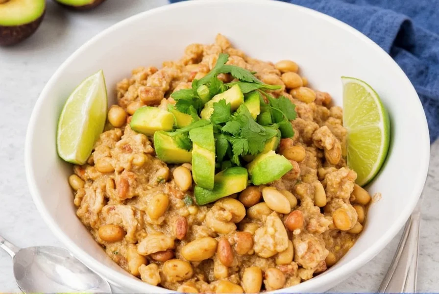 Finished white bean chicken chili in Instant Pot bowl with toppings like avocado, cilantro, and lime wedges