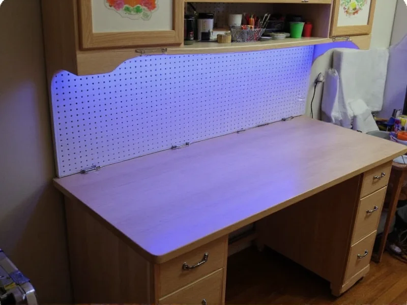 Customized crafting table with pegboard storage and LED lighting