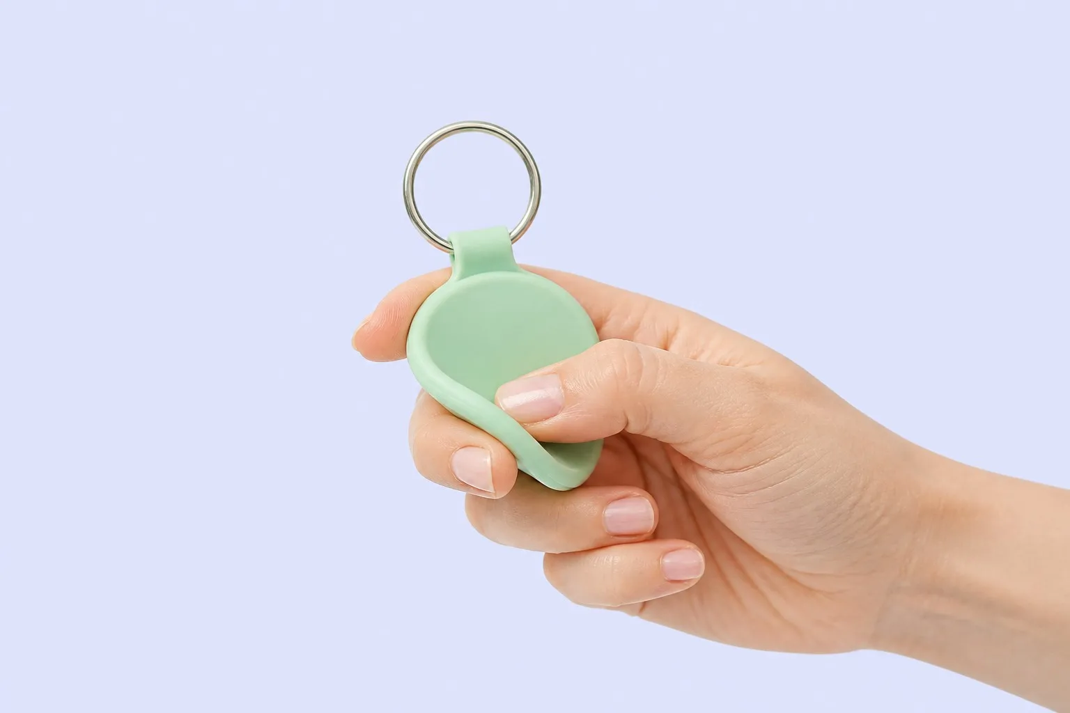 Hand pressing into the soft silicone keychain tag to show flexibility