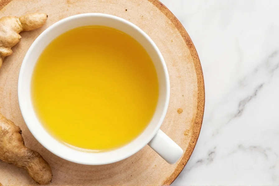 Two mugs of golden ginger turmeric tea with lemon slices on a wooden table