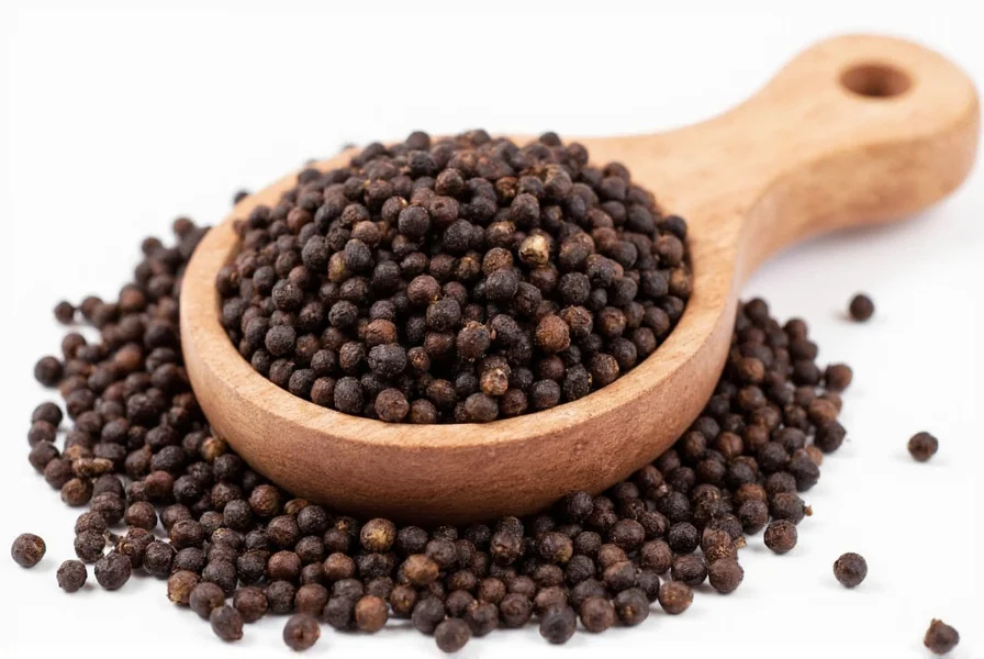 Close-up of freshly ground black pepper on mortar and pestle with whole peppercorns