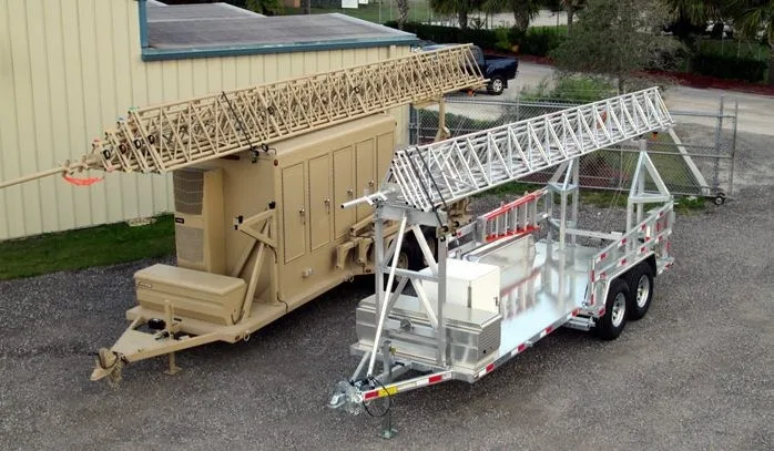 Two trailer mounted lattice towers in a facility yard