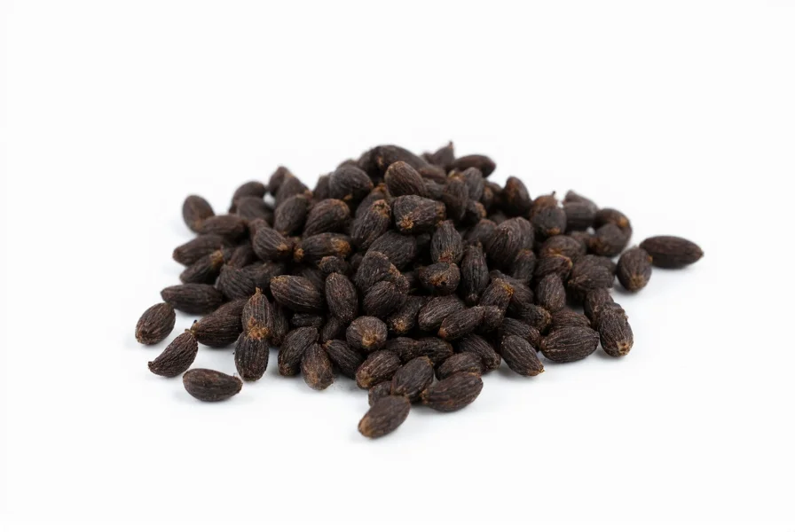 Close-up view of black cumin seeds showing their distinctive black, crescent shape against a white background