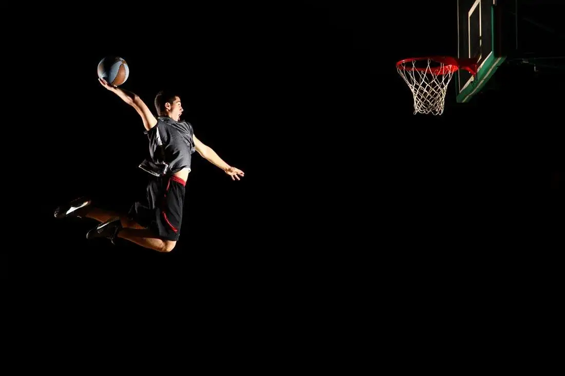 Баскетболист в прыжке на черном фоне