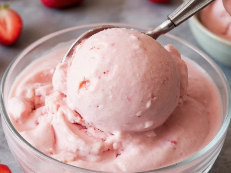 Scooping creamy homemade strawberry ice cream into a glass dish