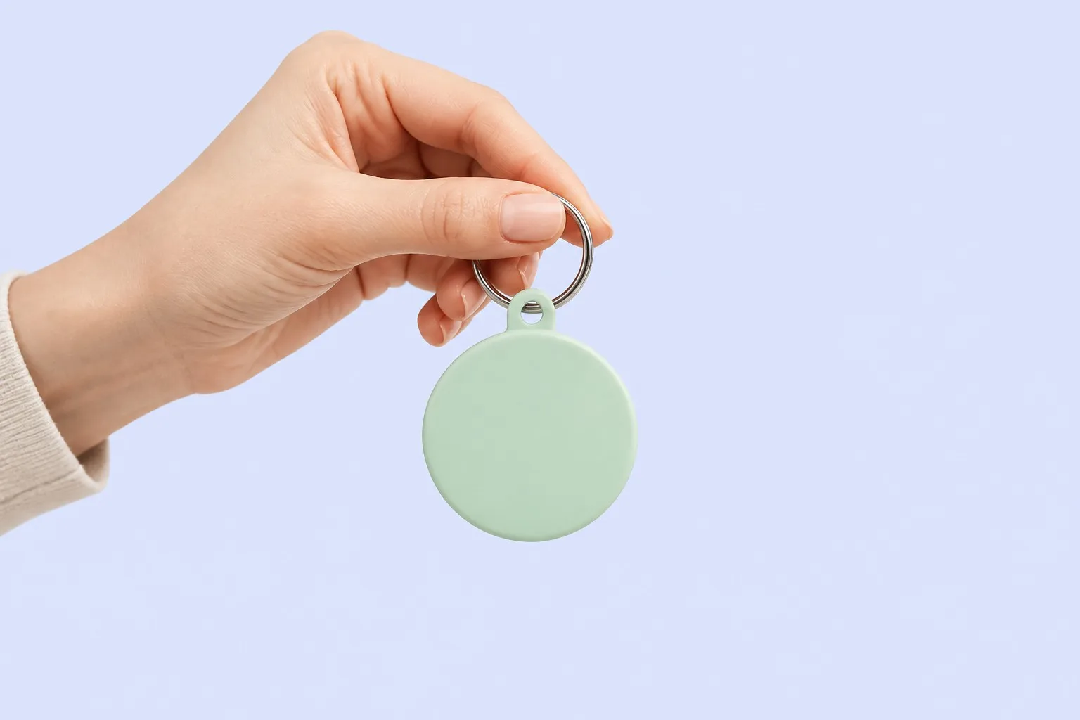 Hand holding a pastel mint green keychain tag
