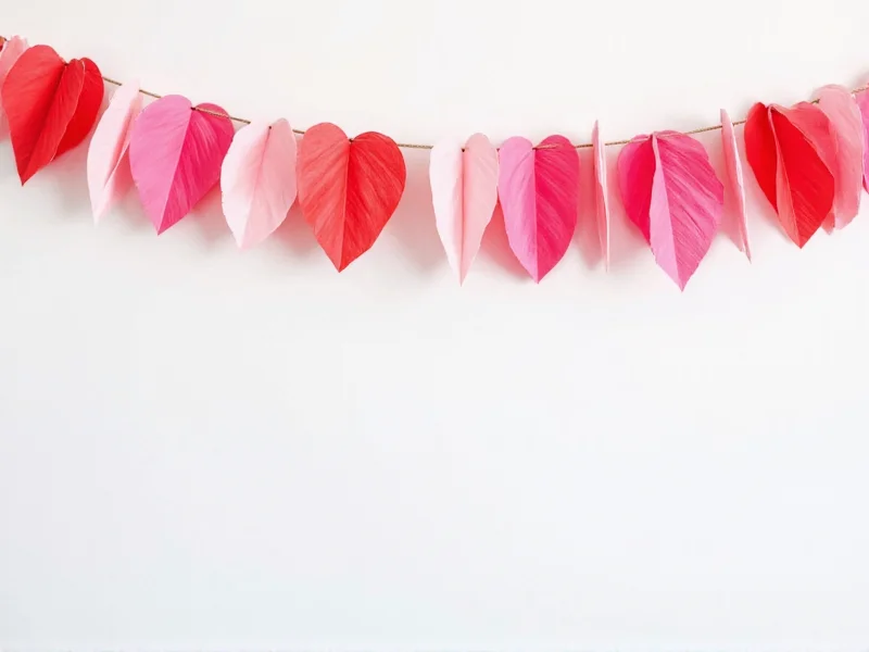 DIY tissue paper heart garland on white wall