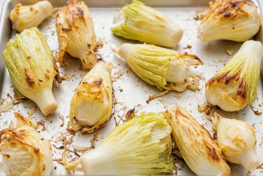 Roasted fennel bulbs on a baking sheet showing caramelized edges