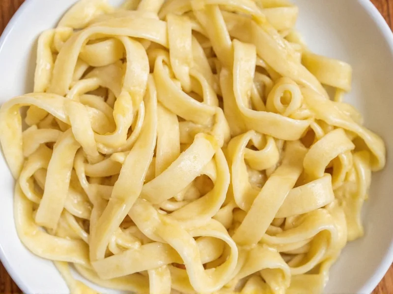 Silky alfredo sauce coating fettuccine strands