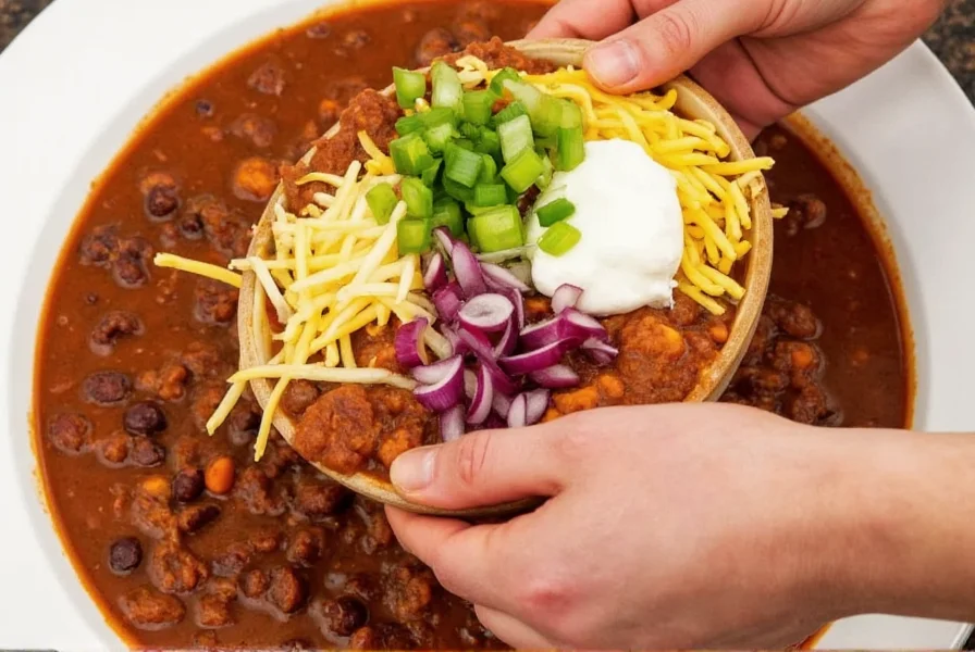 Serving flatlander chili with traditional toppings including shredded cheddar, sour cream, and chopped onions