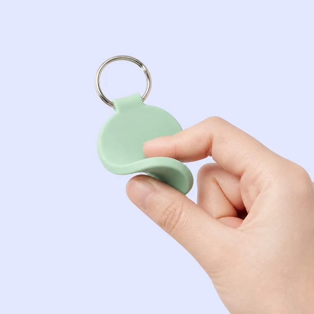 Hand bending the flexible silicone keychain tag to show softness