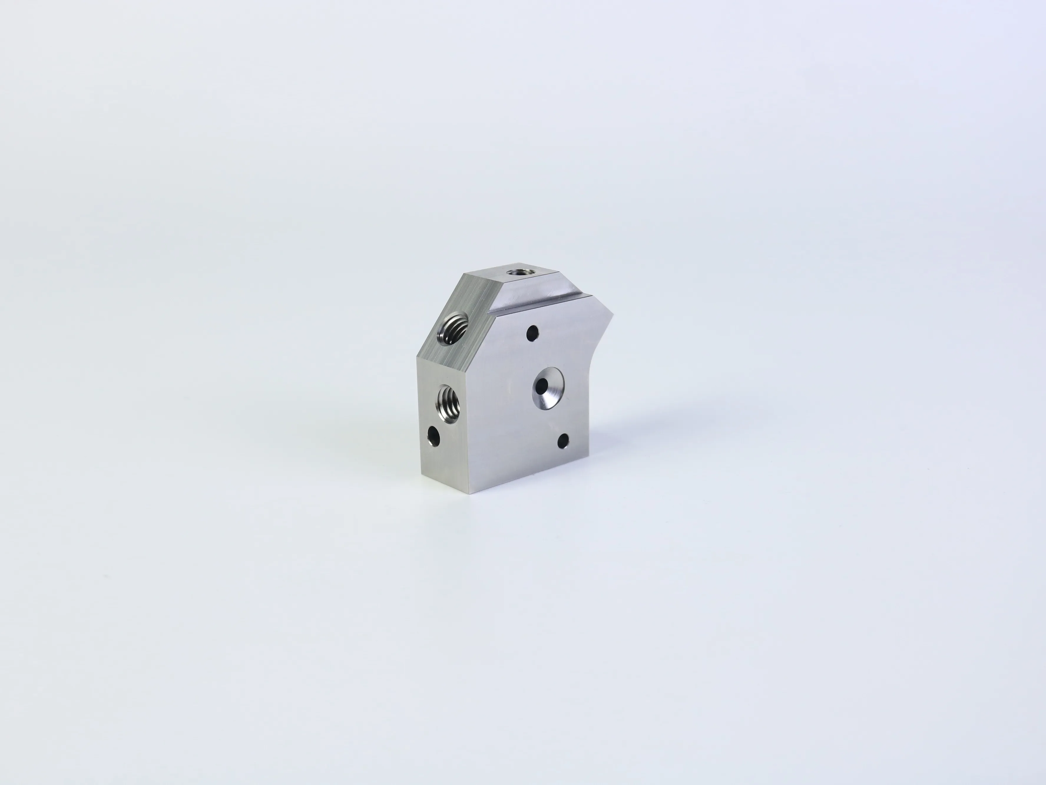 Close-up view of a custom 316L stainless steel CNC milled part with threaded holes