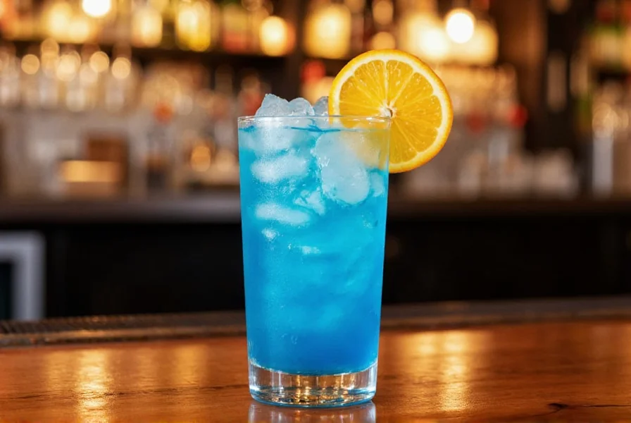 Blue Moon Ginger Dash cocktail in a chilled glass with orange wedge garnish on wooden bar