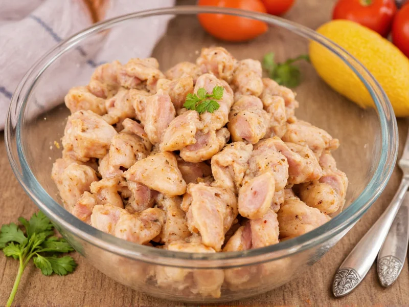 Homemade marinated chicken pieces in glass bowl with herbs