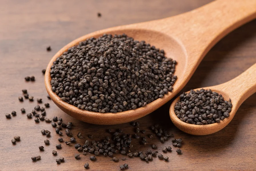 Close-up view of kalonji seeds (nigella sativa) on wooden spoon with measuring spoons showing one teaspoon portion