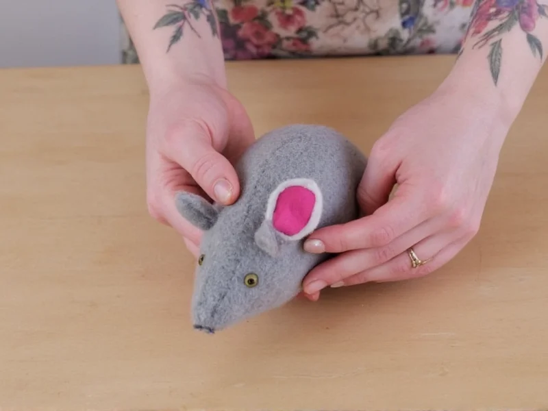 Hands crafting felt mouse toy with recycled fabric scraps