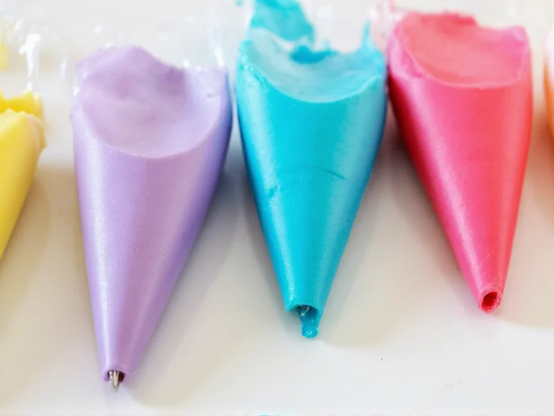 Colorful homemade frosting variations in piping bags