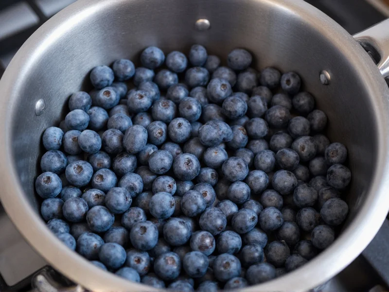 Fresh blueberries simmering in stainless steel pot
