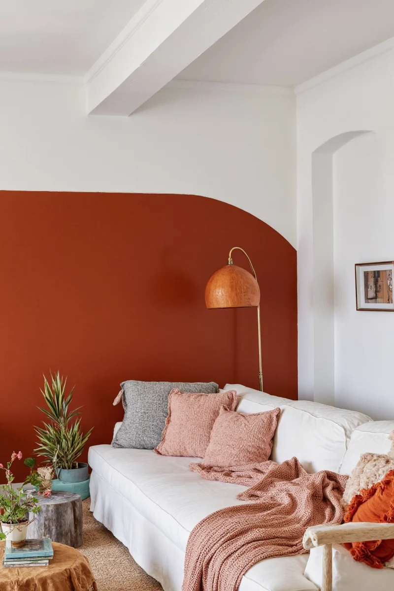 Living room with rust-colored throw pillows and neutral furniture