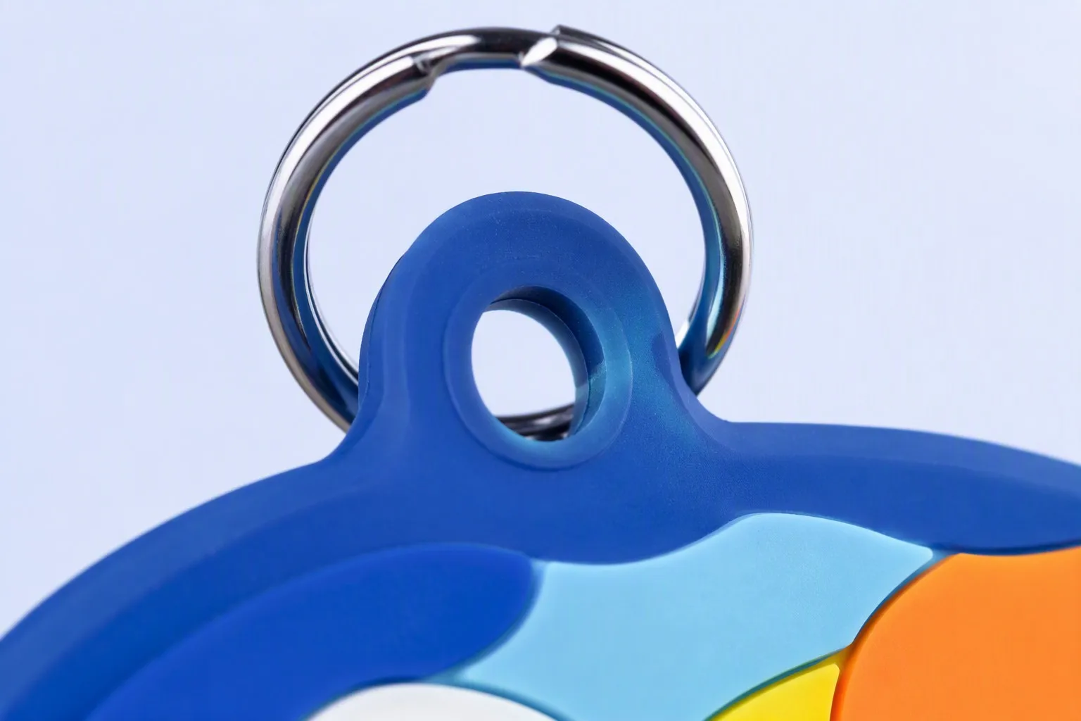 Macro shot of stainless-steel split ring attachment on blue PVC keychain